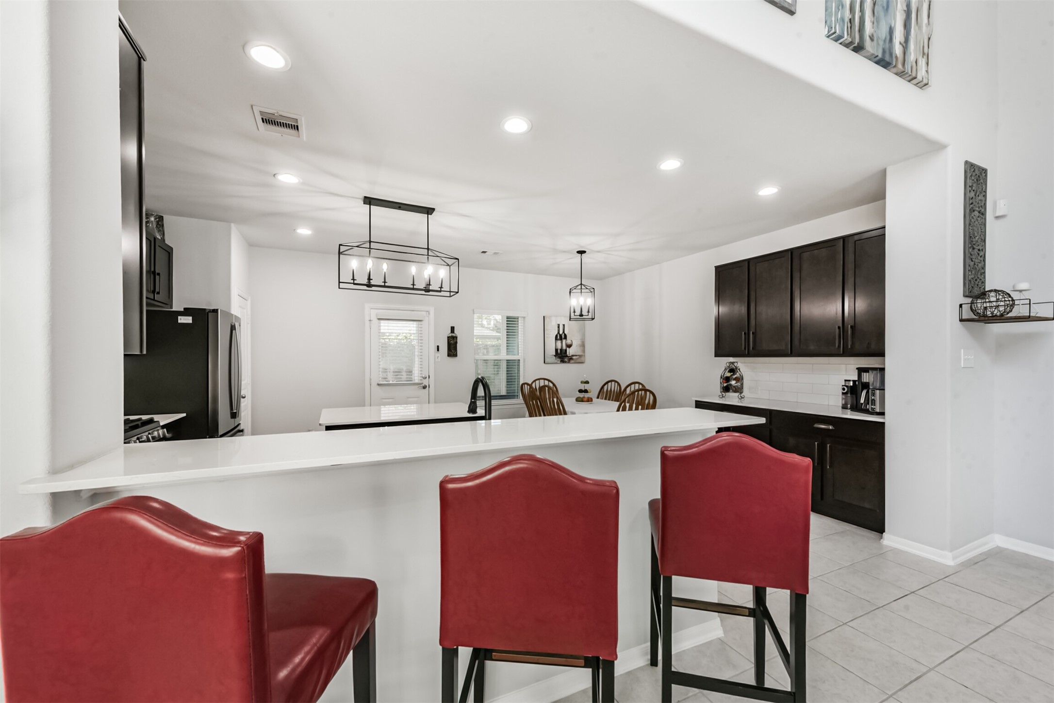 10018 Chase Court Baytown, TX 77521 - Photo 12 of 46 a kitchen with stainless steel appliances kitchen island granite countertop a dining table chairs sink refrigerator and microwave