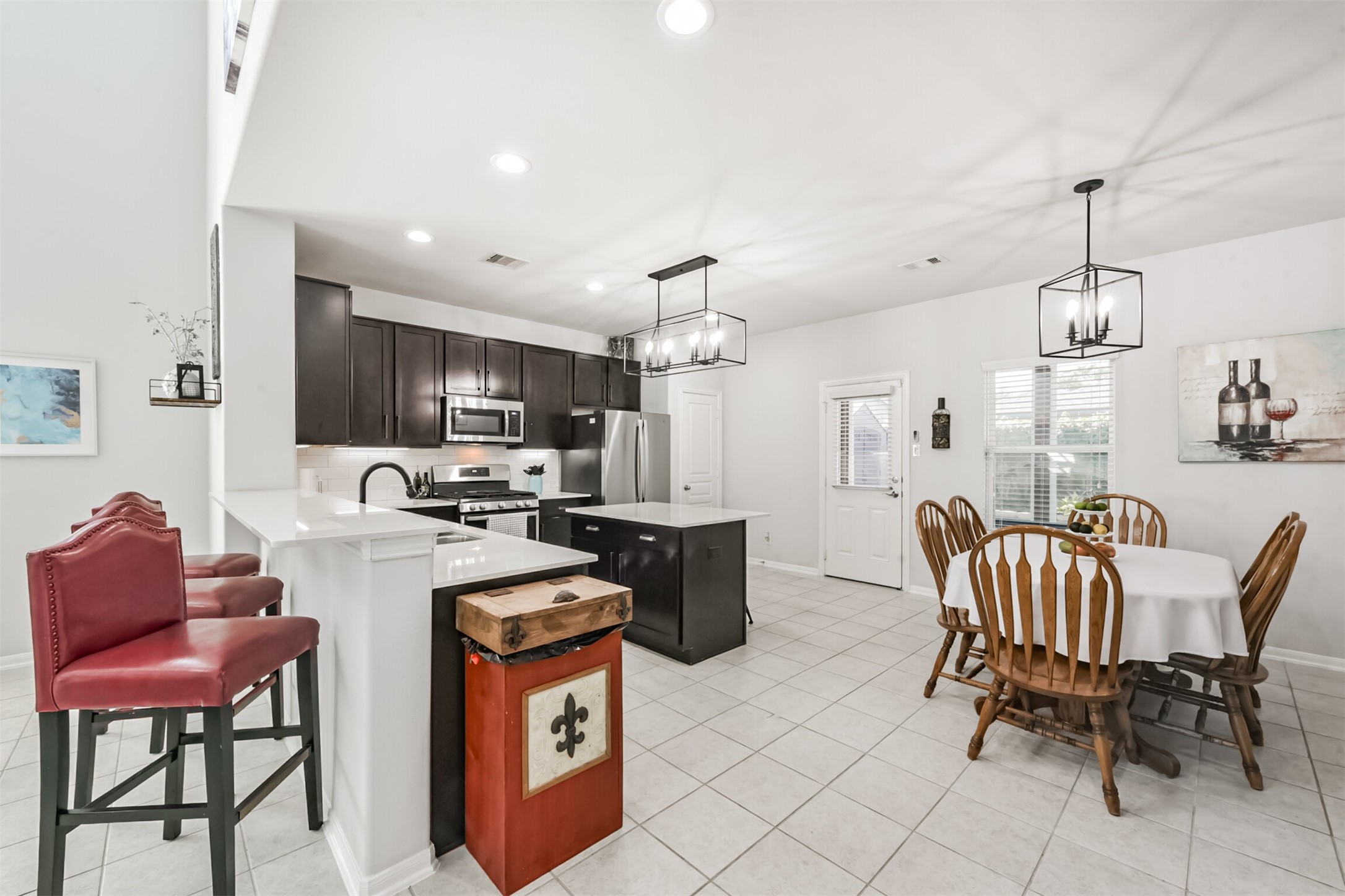 10018 Chase Court Baytown, TX 77521 - Photo 13 of 46 a kitchen with stainless steel appliances kitchen island granite countertop a sink a stove a dining table and chairs