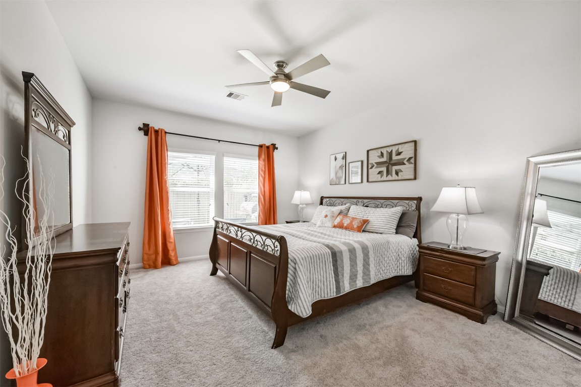 10018 Chase Court Baytown, TX 77521 - Photo 19 of 46 a spacious bedroom with a bed flat screen tv and a large window