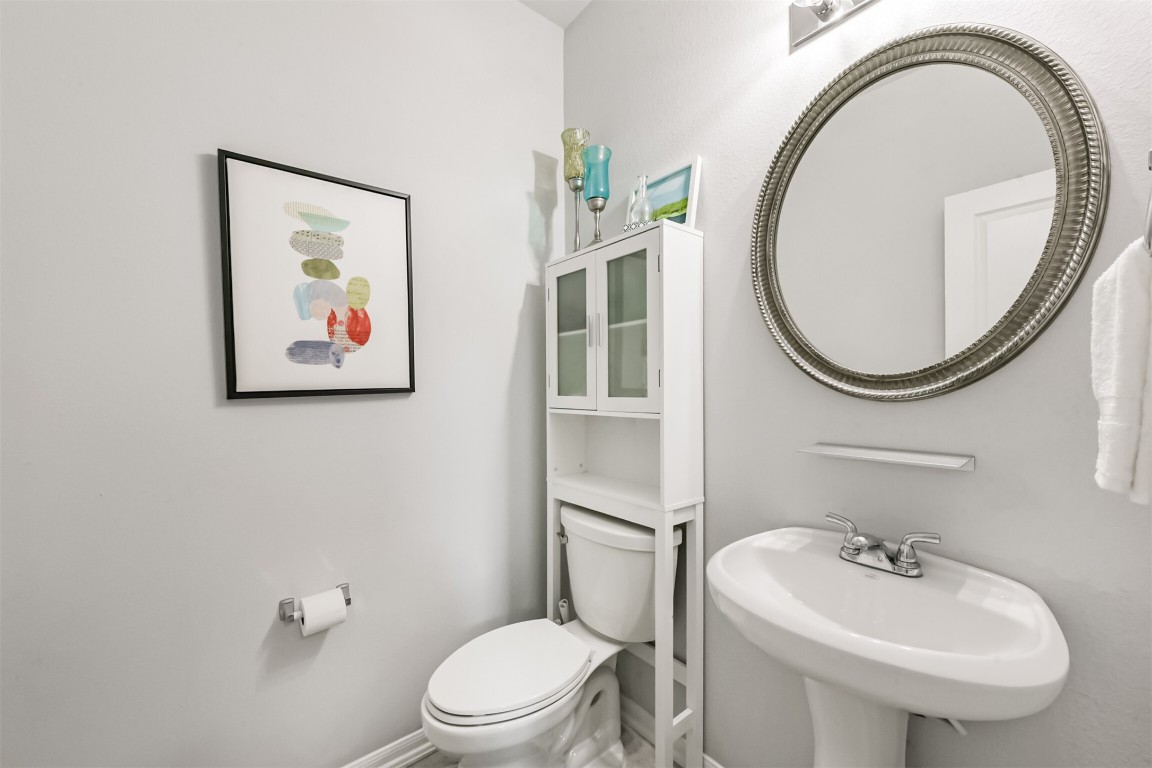 10018 Chase Court Baytown, TX 77521 - Photo 9 of 46 a bathroom with a toilet a sink and a mirror