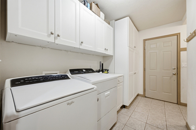5196 Rodeo Circle Oakley, UT 84055 - Photo 31 of 57 Laundry area featuring white cabinetry with silver-tone hardware, tall storage cabinets, and tiled flooring