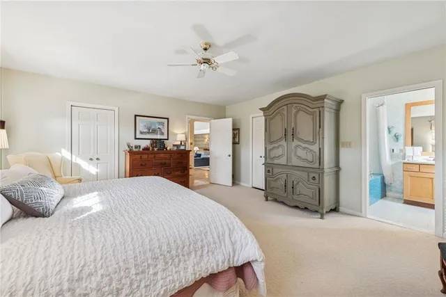 a spacious bedroom with a bed a dresser and mirror