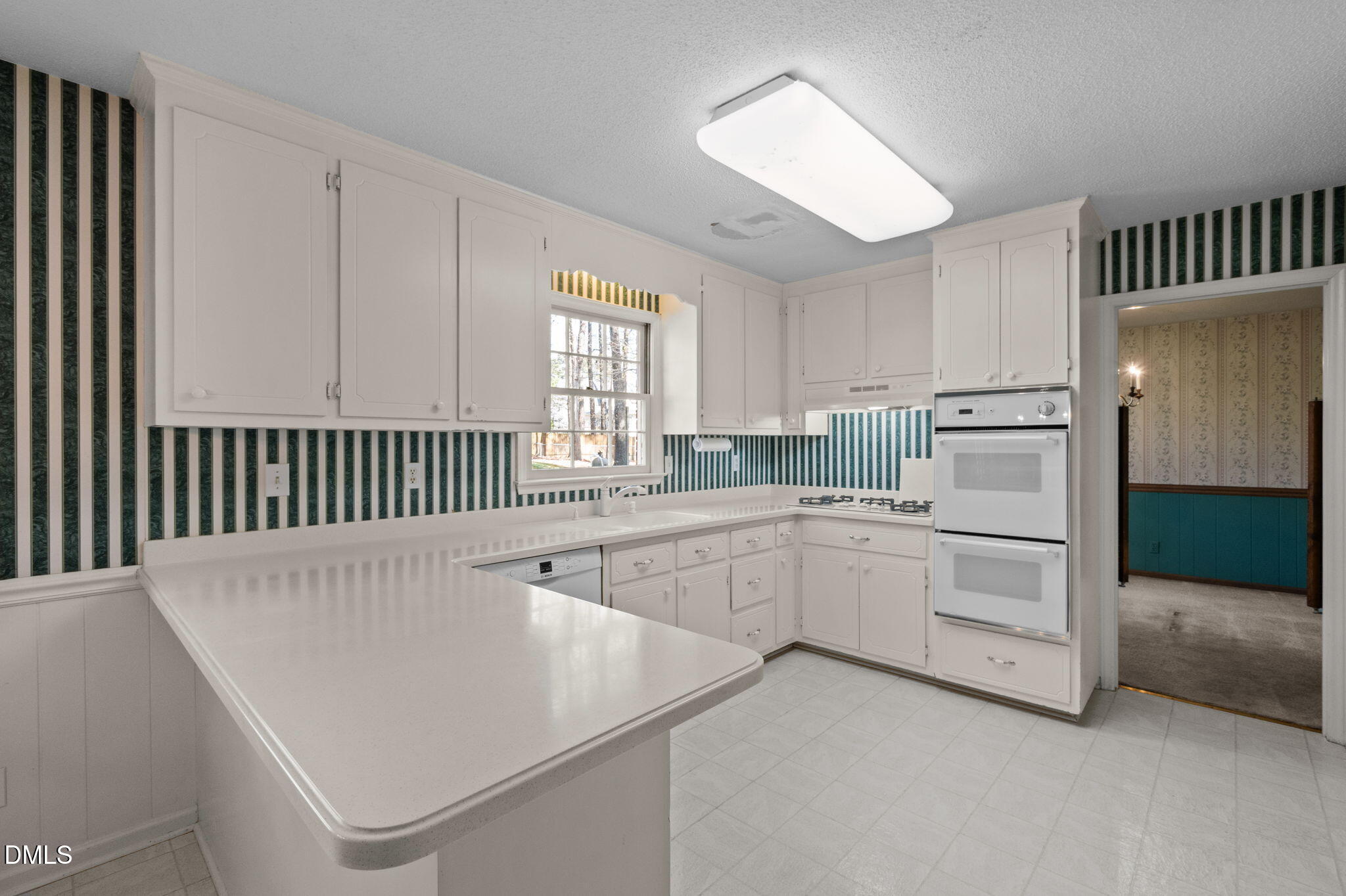 2421 Bonnie Brae Road Durham, NC 27703 - Photo 16 of 55 a kitchen with white cabinets and white appliances