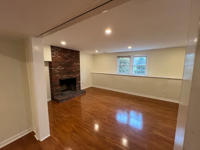 an empty room with wooden floor and fireplace