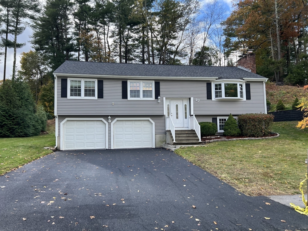 27 Miles Standish Drive, Unit 27 Marlborough, MA 01752 - Photo 2 of 22 a front view of a house with a yard and garage