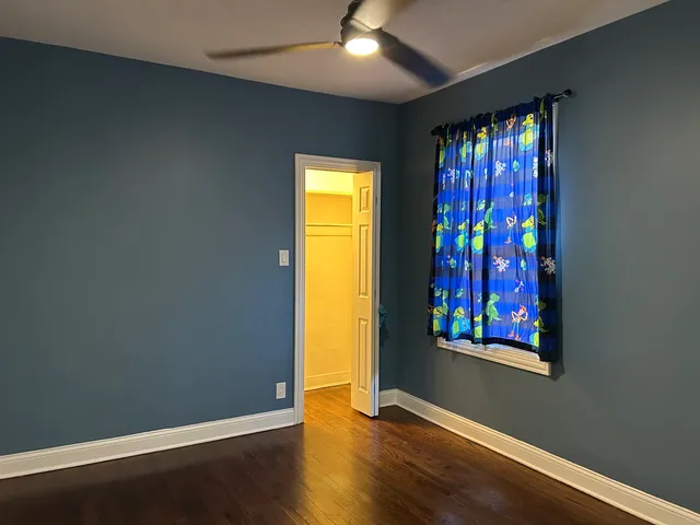 an empty room with wooden floor and window