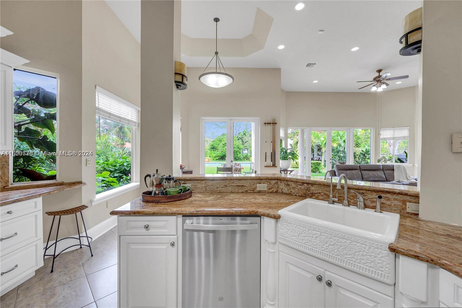 10901 Southwest 91st Street Miami, FL 33176 - Photo 18 of 69 a kitchen with granite countertop a stove a sink a refrigerator and a dining table with wooden floor