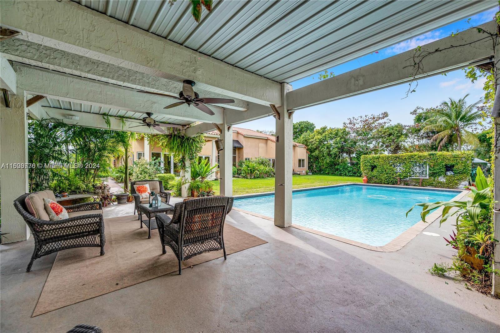 10901 Southwest 91st Street Miami, FL 33176 - Photo 55 of 69 a living room with patio furniture and a floor to ceiling window