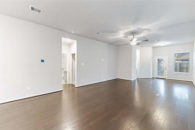 a view of an empty room with wooden floor