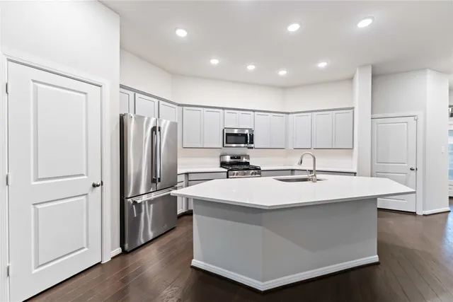 a kitchen with kitchen island a sink appliances and cabinets