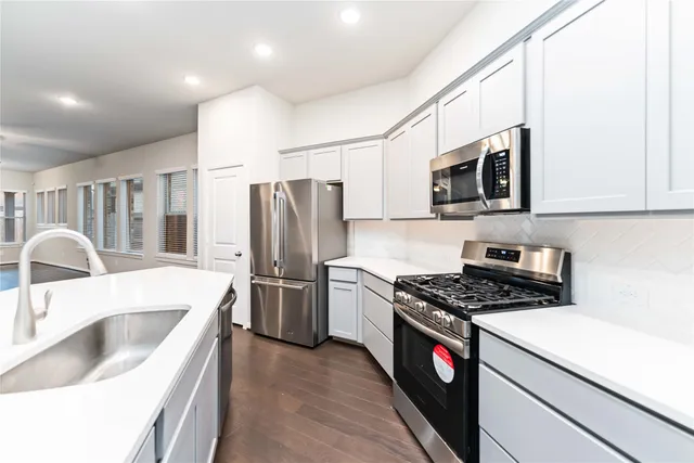 a kitchen with stainless steel appliances granite countertop a sink stove and refrigerator