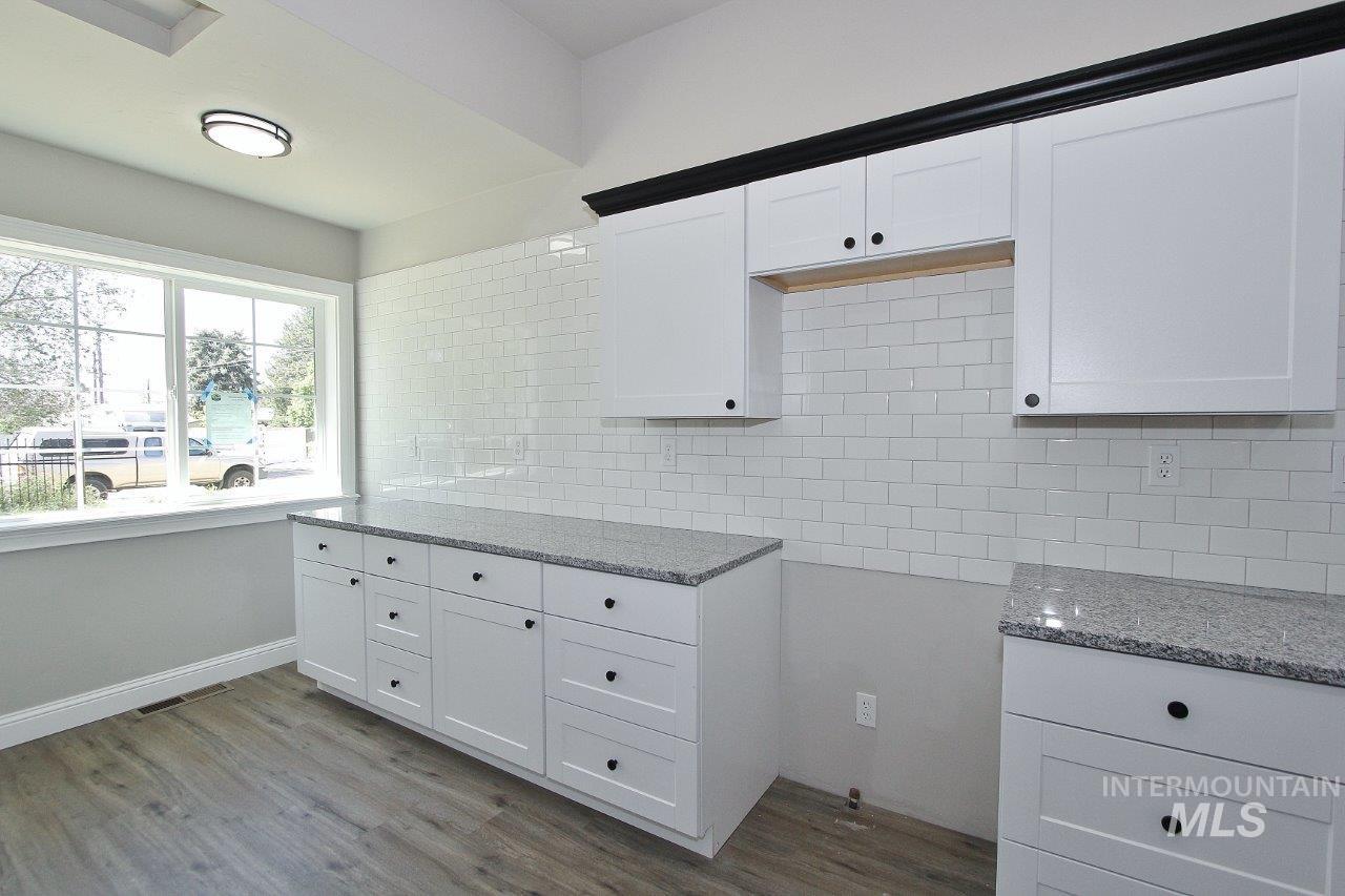 121 Northwest 2nd Street Ontario, OR 97914 - Photo 1 of 32 Modern kitchen space featuring crisp white cabinetry, light-toned countertops, and a full subway tile backsplash
