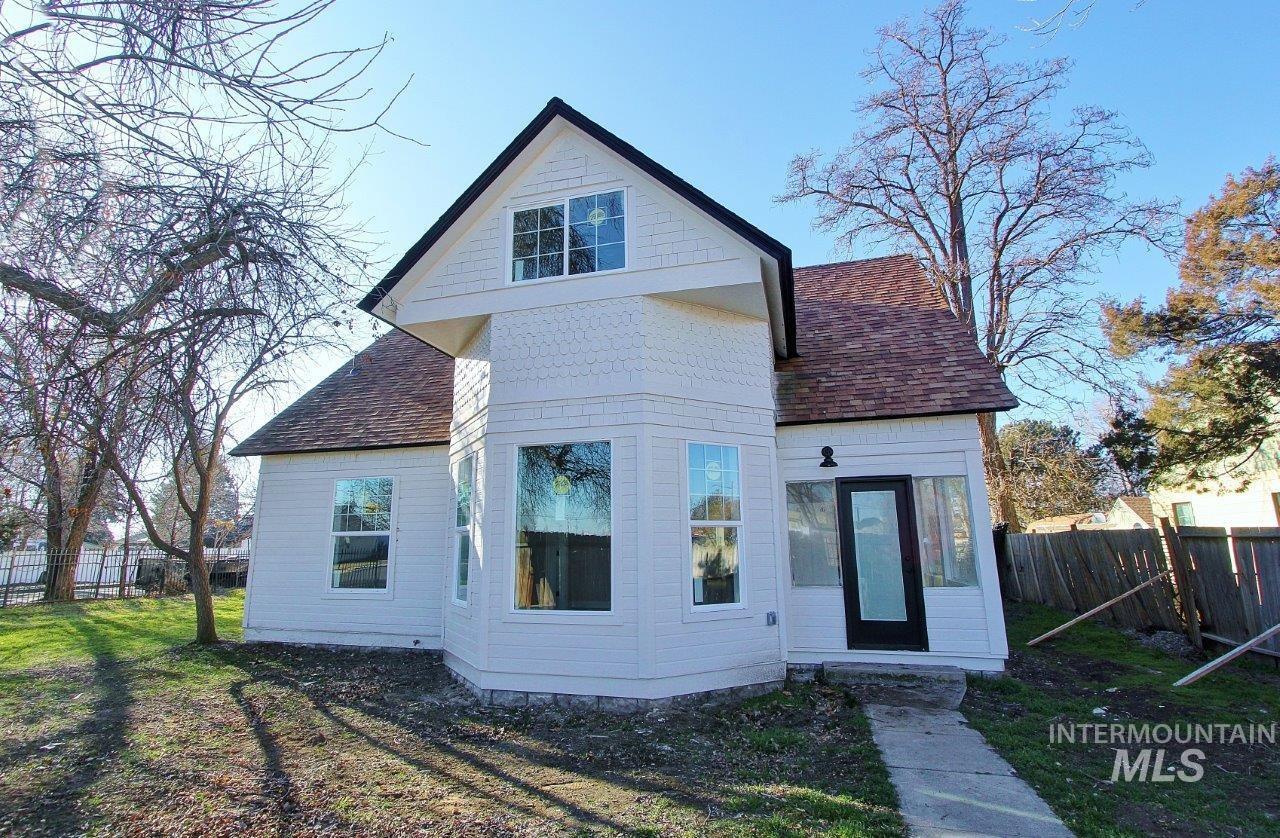 Back of house featuring roof with shingles