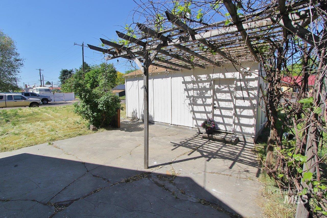 121 Northwest 2nd Street Ontario, OR 97914 - Photo 22 of 32 Concrete patio with an overhead wooden pergola structure providing shade