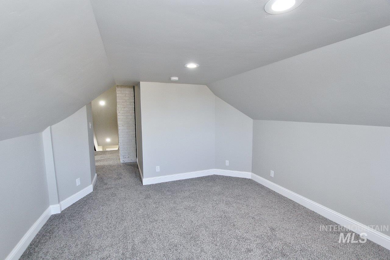 121 Northwest 2nd Street Ontario, OR 97914 - Photo 27 of 32 Additional living space with light carpet, vaulted ceiling, and recessed lighting