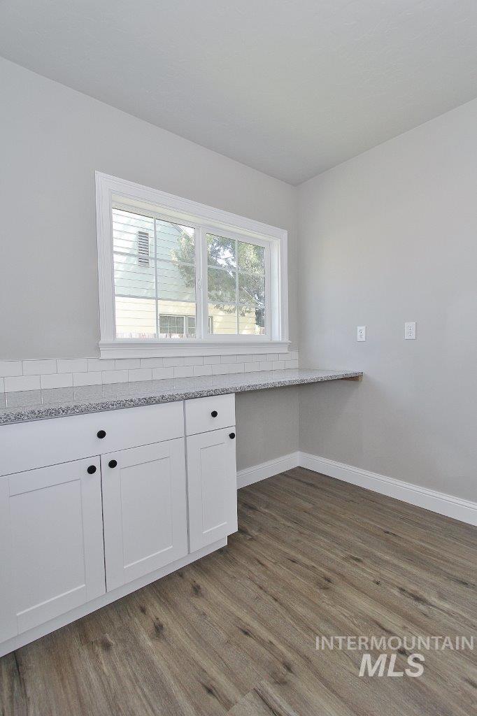 121 Northwest 2nd Street Ontario, OR 97914 - Photo 7 of 32 Built-in white cabinetry with dark hardware, a light speckled countertop, and a white subway tile backsplash