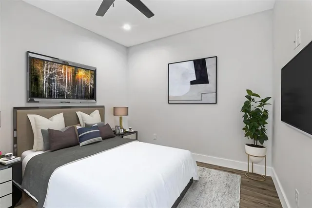 a bedroom with a large bed and a potted plant