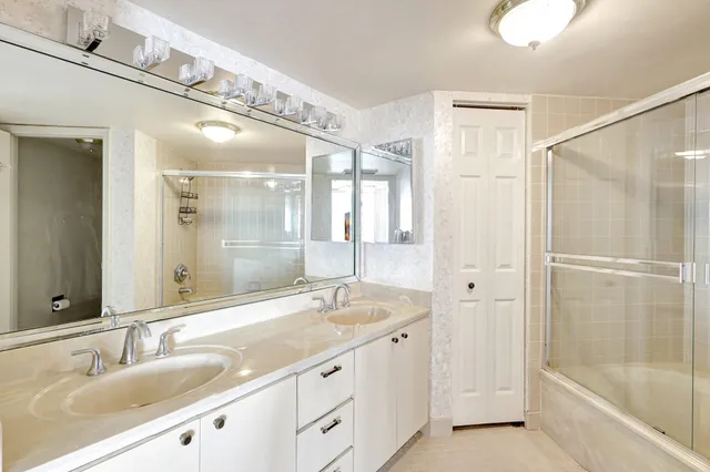 a bathroom with a granite countertop sink mirror and a bathtub