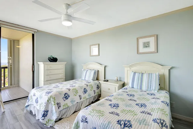 a bedroom with two beds and a chandelier