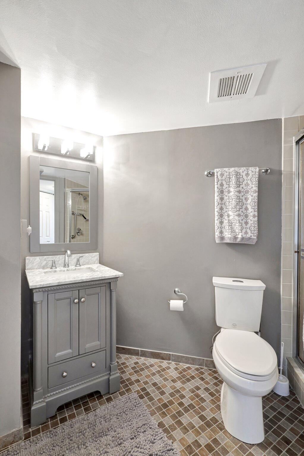 9500 South Ocean Drive, Unit PH10 Jensen Beach, FL 34957 - Photo 33 of 41 a bathroom with a toilet a sink and mirror