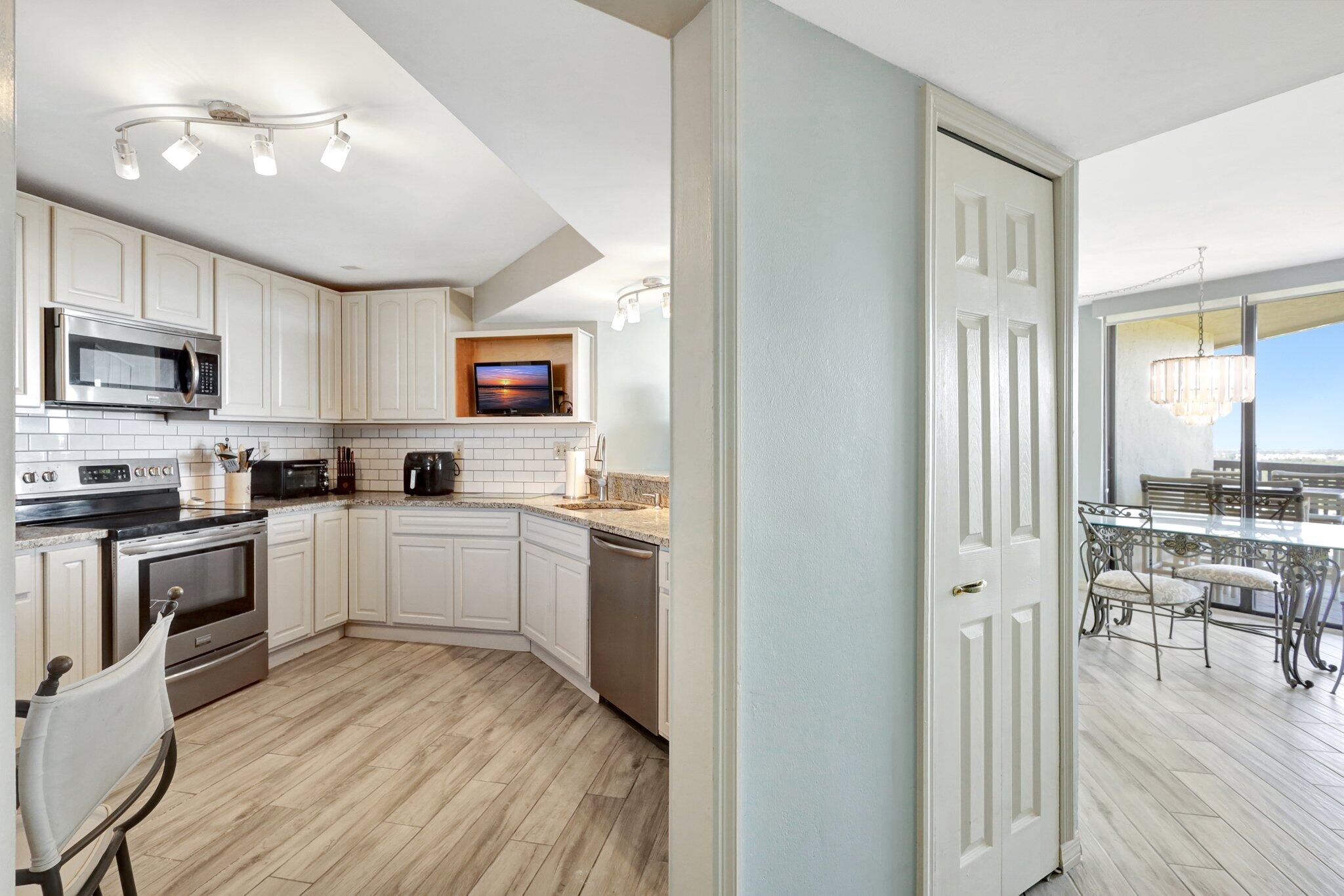 9500 South Ocean Drive, Unit PH10 Jensen Beach, FL 34957 - Photo 4 of 41 a kitchen with sink cabinets and wooden floor