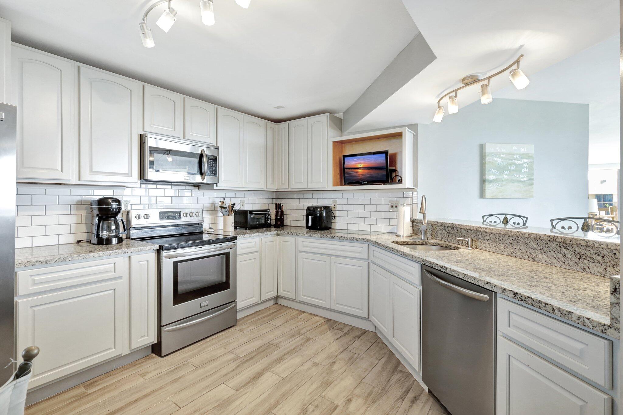 9500 South Ocean Drive, Unit PH10 Jensen Beach, FL 34957 - Photo 5 of 41 a kitchen with stainless steel appliances granite countertop a stove a sink and a microwave