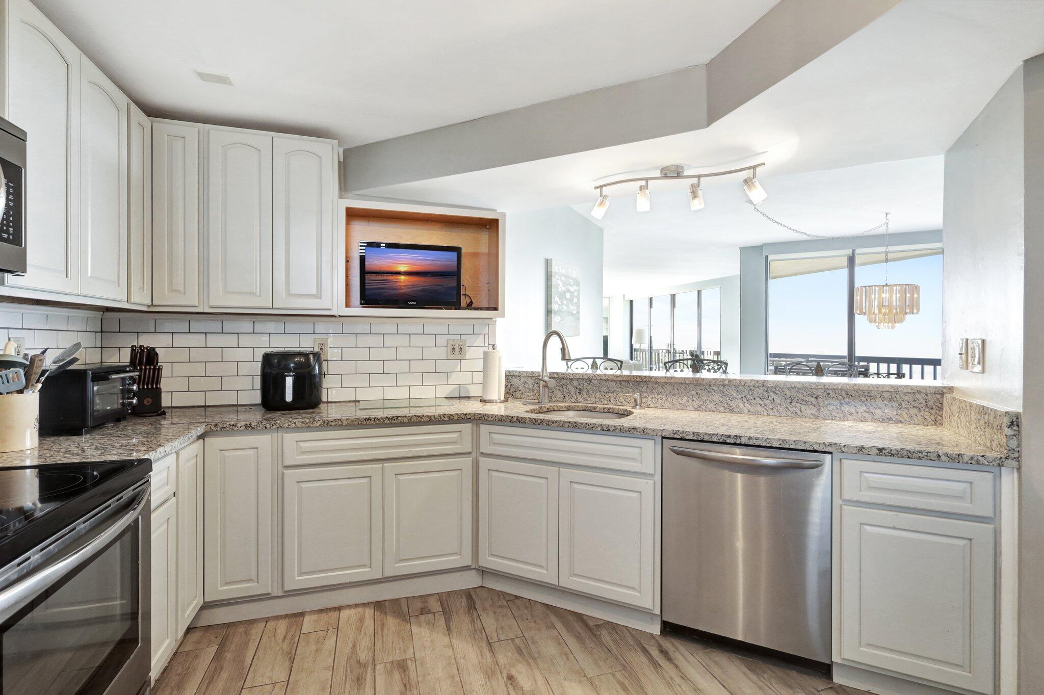 9500 South Ocean Drive, Unit PH10 Jensen Beach, FL 34957 - Photo 6 of 41 a kitchen with white cabinets sink and stove