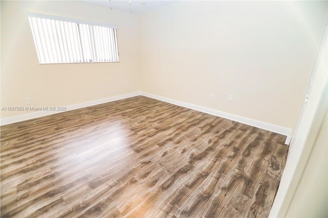 1654 Northeast 151st Street Miami, FL 33162 - Photo 12 of 19 an empty room with wooden floor and windows