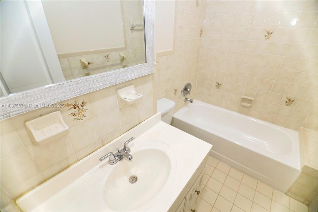 1654 Northeast 151st Street Miami, FL 33162 - Photo 18 of 19 a bathroom with a tub sink and mirror