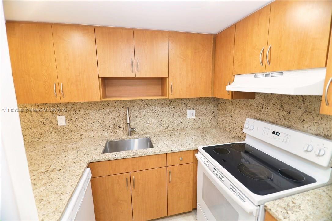 1654 Northeast 151st Street Miami, FL 33162 - Photo 5 of 19 a kitchen with a sink a stove and cabinets