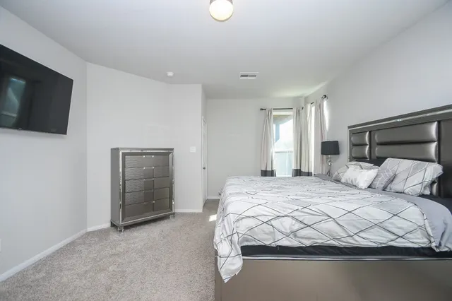 a bedroom with a bed and a flat screen tv