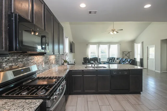 a kitchen with a sink stove and microwave