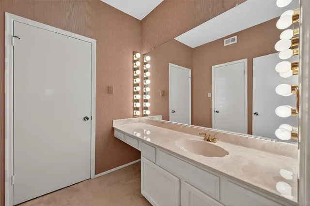 a bathroom with a sink a toilet and mirror