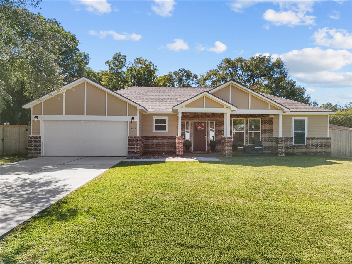 a front view of a house with yard and green space