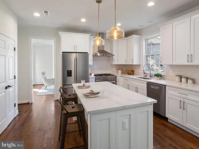 a kitchen with a sink a stove a refrigerator and white cabinets