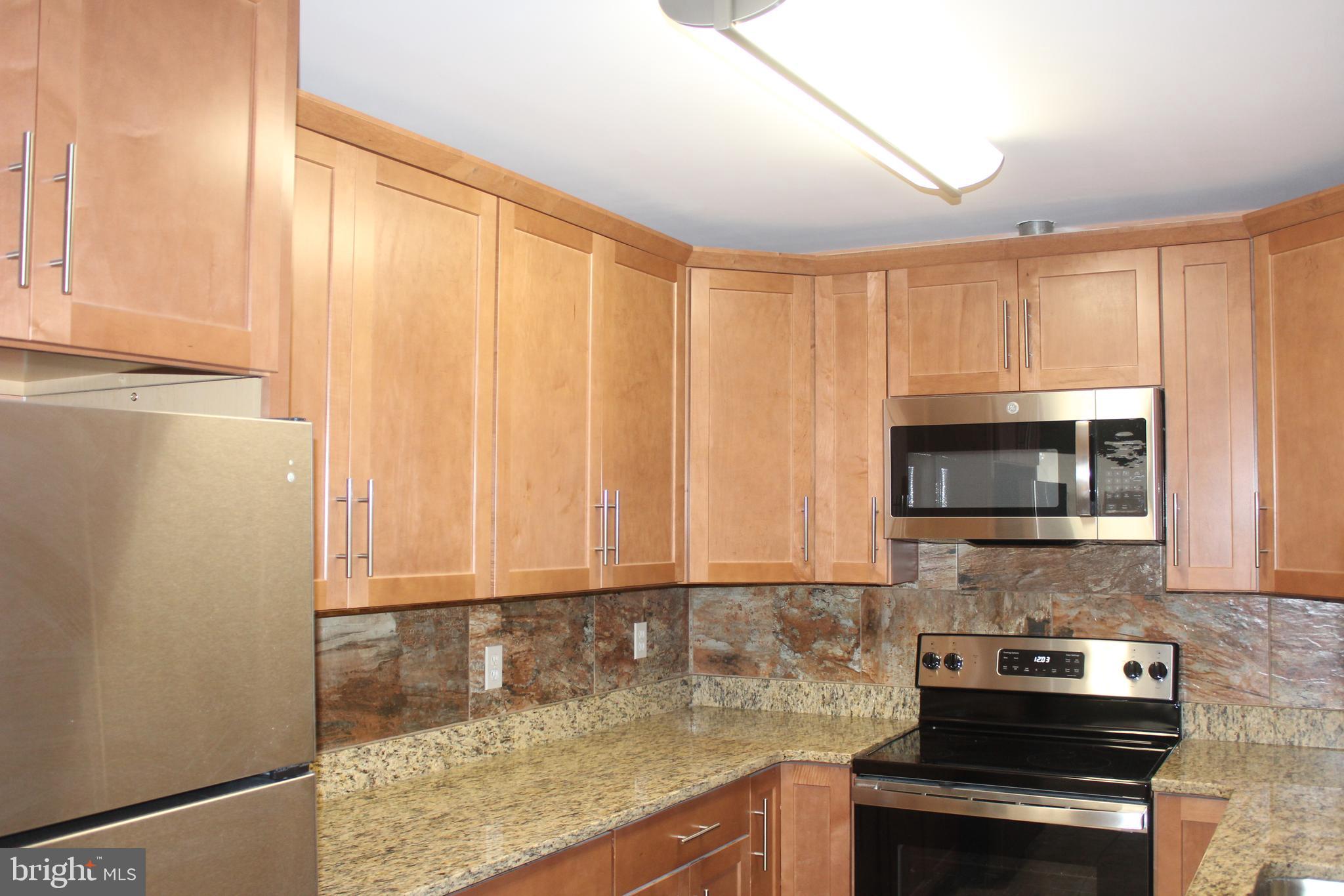 747 Garden Drive Harrisburg, PA 17111 - Photo 12 of 34 a kitchen with granite countertop a sink a stove and cabinets
