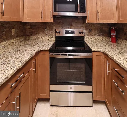 a kitchen with stainless steel appliances granite countertop a stove and a cabinets