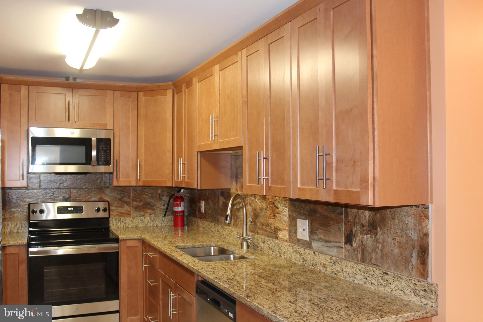 747 Garden Drive Harrisburg, PA 17111 - Photo 15 of 34 a kitchen with stainless steel appliances granite countertop a sink a stove and a microwave