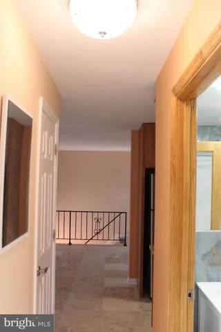 a view of a hallway with a door and stairs