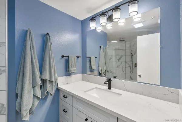 a bathroom with a sink a large mirror and a shower