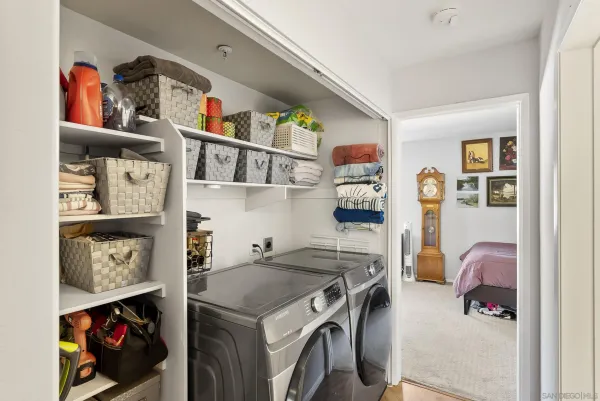 a utility room with dryer washer and a view of living room