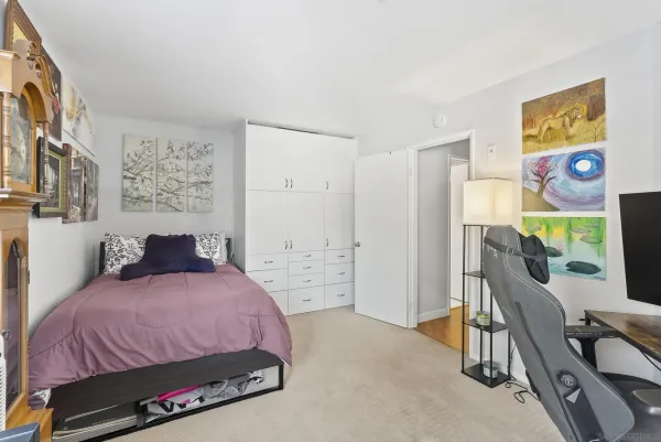 a bedroom with a bed a dresser and next to a window