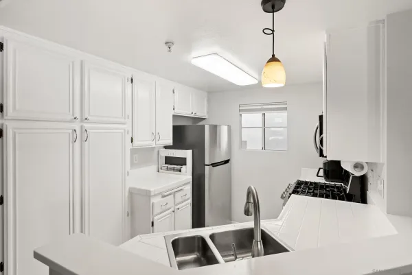 a kitchen with white cabinets and stainless steel appliances
