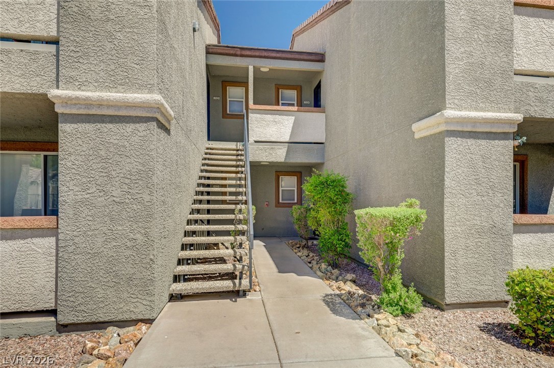 555 East Silverado Ranch Boulevard, Unit 2124 Las Vegas, NV 89183 - Photo 2 of 47 Concrete pathways lead to multi-level entryways, framed by manicured shrubbery and desert-friendly landscaping.