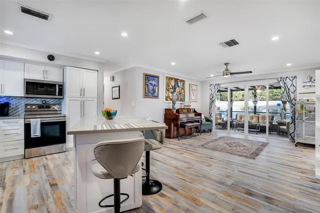 a living room with furniture a flat screen tv and a dining table