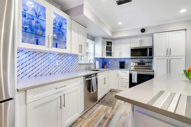 a kitchen with cabinets and steel appliances