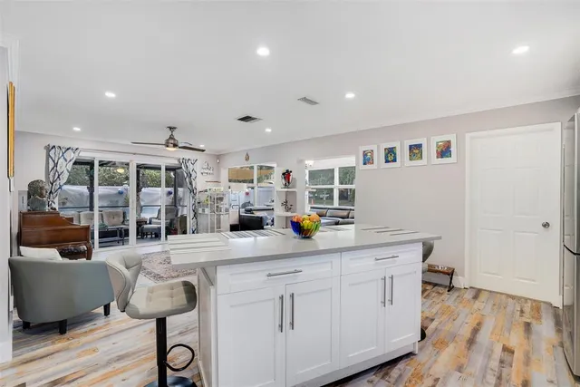 a kitchen that has a lot of cabinets and wooden floor