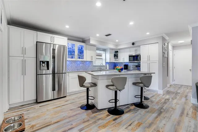 a kitchen with stainless steel appliances granite countertop a refrigerator and a stove top oven