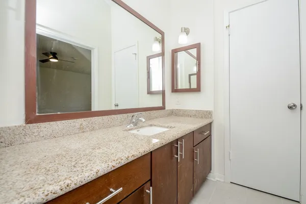 a bathroom with a granite countertop sink and a mirror