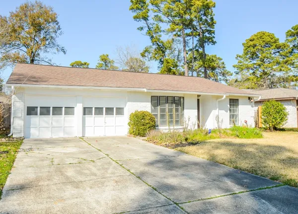 a front view of a house with a yard and potted plants